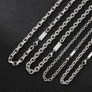 Detail of four stainless steel O-chains with blank rectangular tags on black background