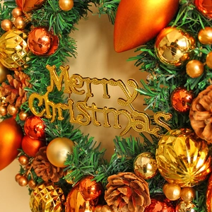 Christmas wreath with golden pine cones and Merry Christmas sign for holiday door decor