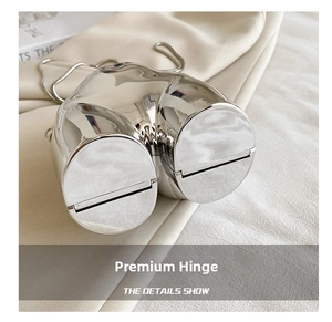 Detail of high-quality metal hinge on silver artistic torso shaped mini bag