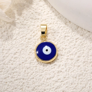 Macro shot of circular blue Evil Eye charm with gold-plated edges and enamel details