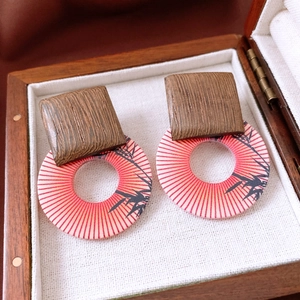 Detail of retro wooden earrings with red bamboo print on a fabric jewelry box liner