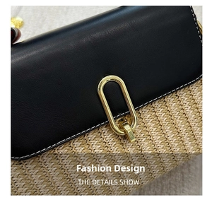 Detail of woven straw handbag with black pebbled leather flap and golden metal buckle