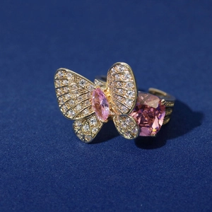Macro detail of golden butterfly ring with pink marquise and heart-shaped zircon stones