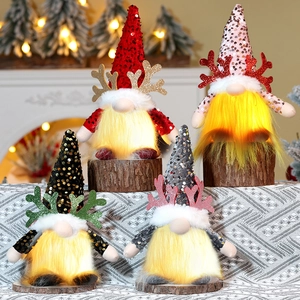 Close-up of lighted Christmas gnomes with sequins and antlers on wooden base