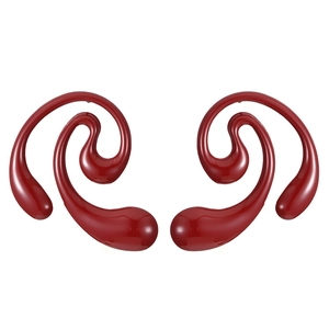 Detail shot of deep red spiral earrings with smooth curves and a glossy polished finish