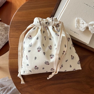 Close-up of floral cotton drawstring bag with red and blue patterns on wooden table