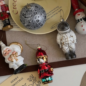 Flat lay of astronaut and Santa themed Christmas hanging ornaments set for holiday decor