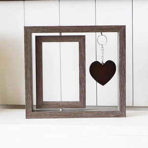 Close-up of a rotating wooden pet memorial frame with a brown heart-shaped pendant detail