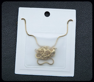 Detail of a gold swan pendant necklace with a fine rectangular chain on white card display