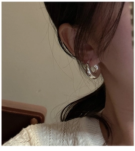 Gros plan de boucles d'oreilles créoles argentées épaisses pour un look minimaliste