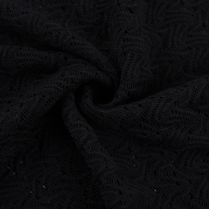 Gros plan sur la dentelle noire complexe et le travail de crochet ajouré de la robe