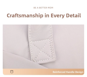 Detail of reinforced cross-stitching on the light gray diaper bag for enhanced durability