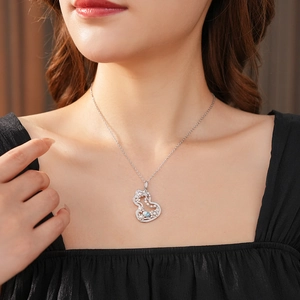Detailed view of gourd-shaped pendant necklace with white zircons and light blue gemstone