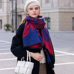 Red and navy blue patchwork scarf worn by model in a stylish urban city setting