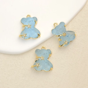 Detailed close-up of translucent blue bear pendants with gold star accents and cubic zirconia