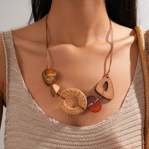 Détail du collier bohème avec anneaux en rotin, blocs en bois et pendentifs en résine