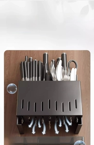 Macro detail of wall-mounted stainless steel kitchen rack with drainage and tool storage