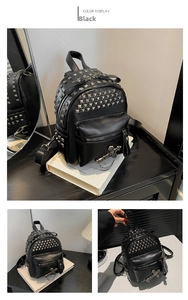 Detail of black punk mini backpack with silver rivets, metal chains and cross charms
