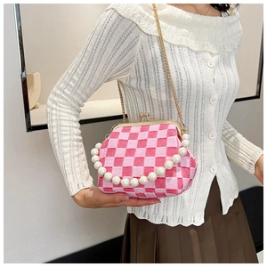 Detail of pink checkerboard tweed bag with pearl handle and metal clasp closure