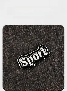 Detailed close-up of the metal Sport logo on the dark textured fabric of the baseball cap