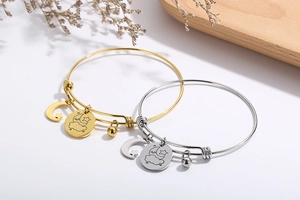 Detail of gold and silver adjustable bracelets with star, moon and cloud charms