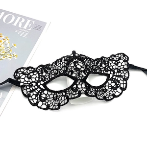 Detailed close-up of black lace masquerade mask with intricate floral patterns and ribbons