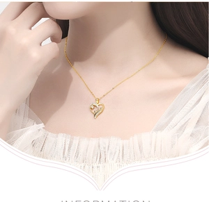 Close-up of golden hollow heart necklace with tiny sparkling zircons worn by a model