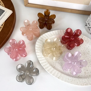 Translucent flower hair clips in jelly colors on a white vintage tray setting