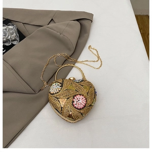 Close-up of heart-shaped evening clutch with gold sequins and colorful floral beadwork