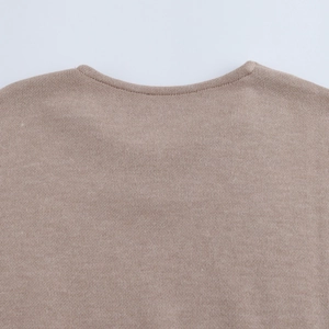 Close-up of a soft light brown knit top showing the round neck design and fabric texture