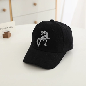 Close-up of black cotton baseball cap featuring detailed white dinosaur skeleton embroidery