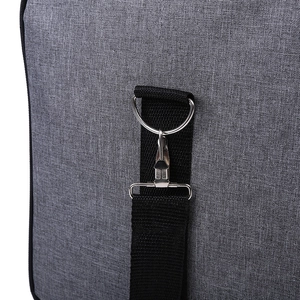 Detail of silver metal hook and D-ring on grey oxford fabric travel bag with black strap