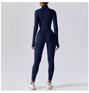 Detail view of navy blue high-waist yoga leggings and long sleeve top with thumb holes