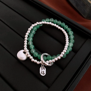 Detail of double-layer bead bracelet with green jade-like beads and 福 pendant