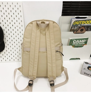 Vista trasera de la mochila de nailon beige con correas acolchadas y cinta para maleta