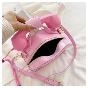 Detailed top view of pink retro telephone shaped crossbody bag with zipper closure
