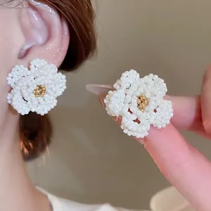 Elegant beaded camellia flower stud earrings with white petals and golden center accents