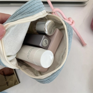 Interior detail of light blue corduroy makeup bag showing spacious storage for cosmetics