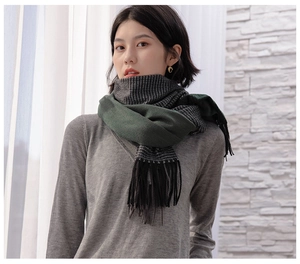 Detail of dark green and black-and-white checkered scarf with tassel fringe edges