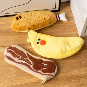 Macro shot of cute plush pencil cases in fried shrimp, banana, and bacon designs with soft texture