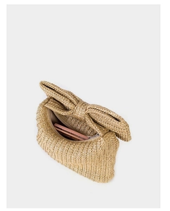 Detail view of the zipper closure and interior storage of this beige straw bow handbag