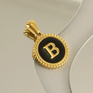 Detailed close-up of an 18K gold letter B pendant with black enamel finish