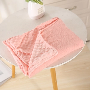 Detail of pink minky dot baby blanket showing 3D bubble texture and cotton gauze side