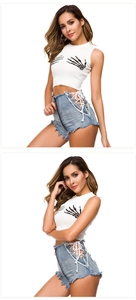Dettaglio degli shorts in denim a vita alta con lacci e crop top bianco con stampa teschio