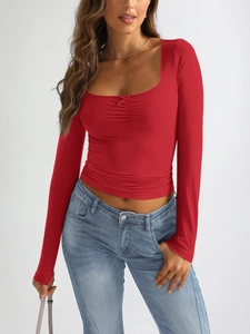Detail of red long sleeve U-neck top featuring ruched chest and cute bow knot detail