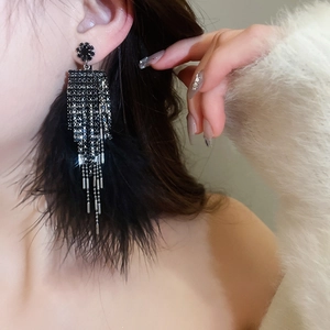 Gothic black rhinestone tassel earrings with feathers shown as a close-up on model