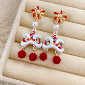 Detail view of festive Chinese lion dance earrings with red pom-poms and white pearls