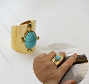 Detail of 18K gold plated wide band ring with oval turquoise and adjustable opening
