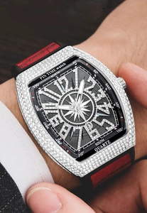 Close-up of men's iced-out tonneau watch with red and black strap on wrist