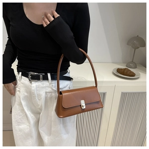 Close-up of brown PU leather baguette bag featuring a stylish golden rectangular buckle